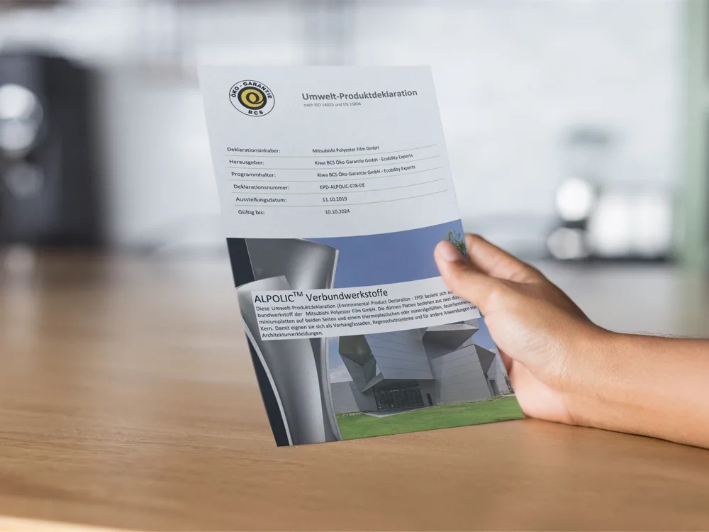 Zu sehen ist eine Hand auf dem Schreibtisch, die die Umweltproduktdeklaration hoch hält.