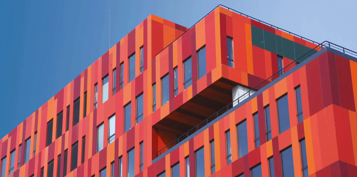Fotografie einer Gebäudefassade in verschiedenen Rot- und Orangetönen